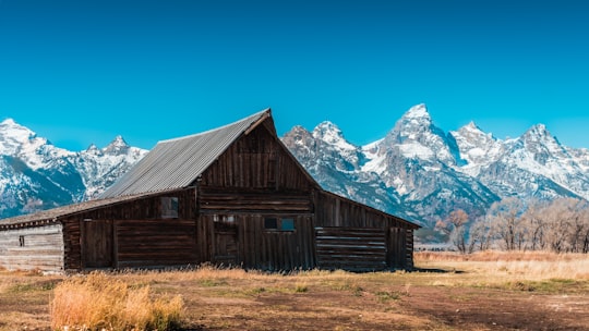 brown wooden house near gray and white snowed mountains in Grand Teton National Park United States