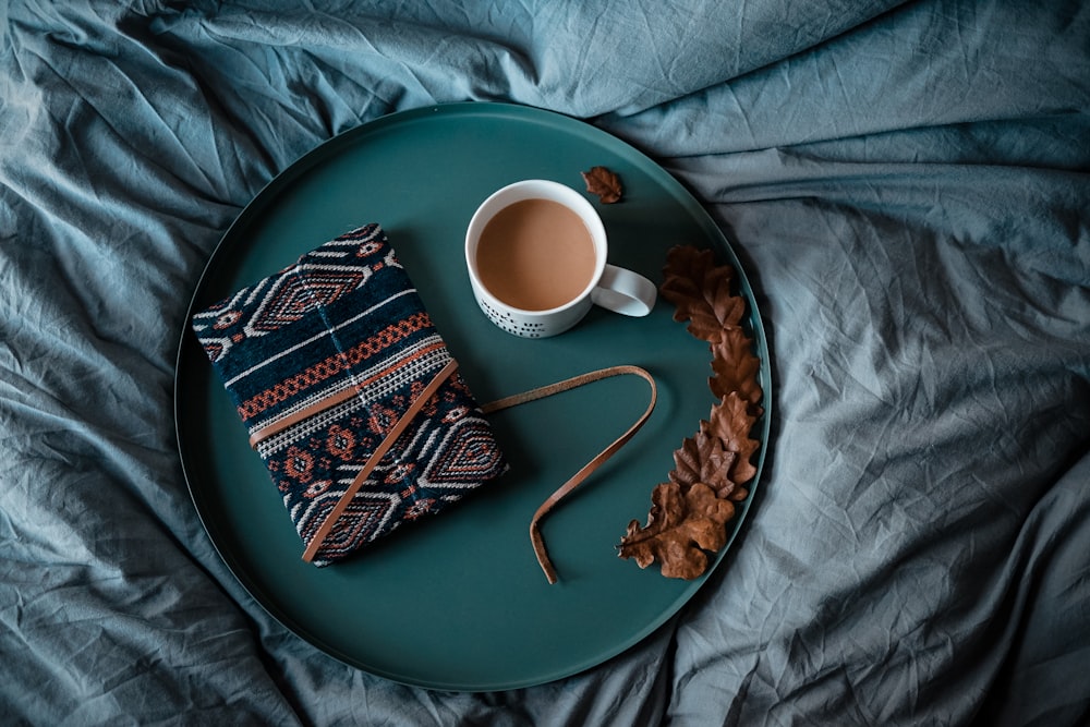 Mug en céramique blanche sur plateau rond vert