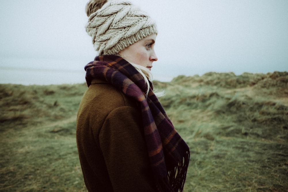 Mujer de pie en el césped con ropa de invierno durante el día