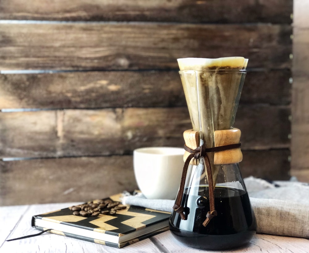 clear glass pitcher beside book