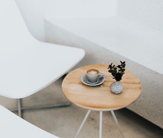 round brown table beside two white chairs