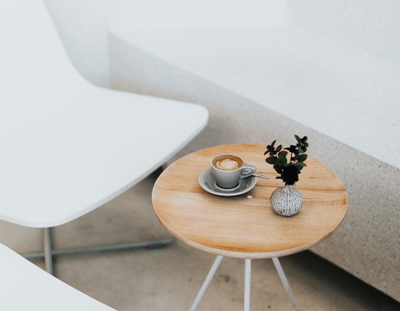 round brown table beside two white chairs