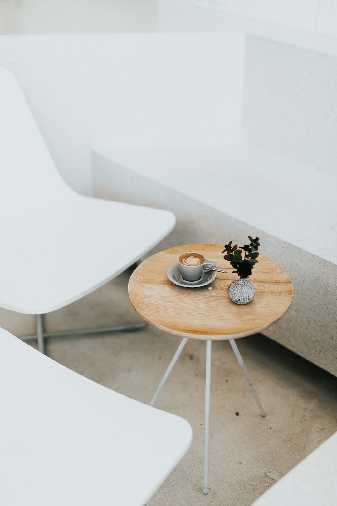 round brown table beside two white chairs