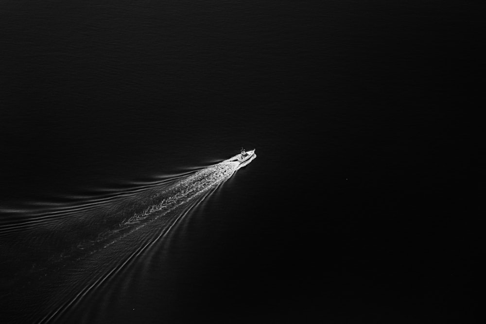 Fotografía en escala de grises de un barco en un cuerpo de agua