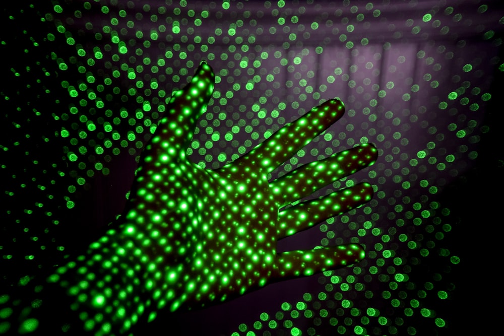 person showing her hand with green LED lights