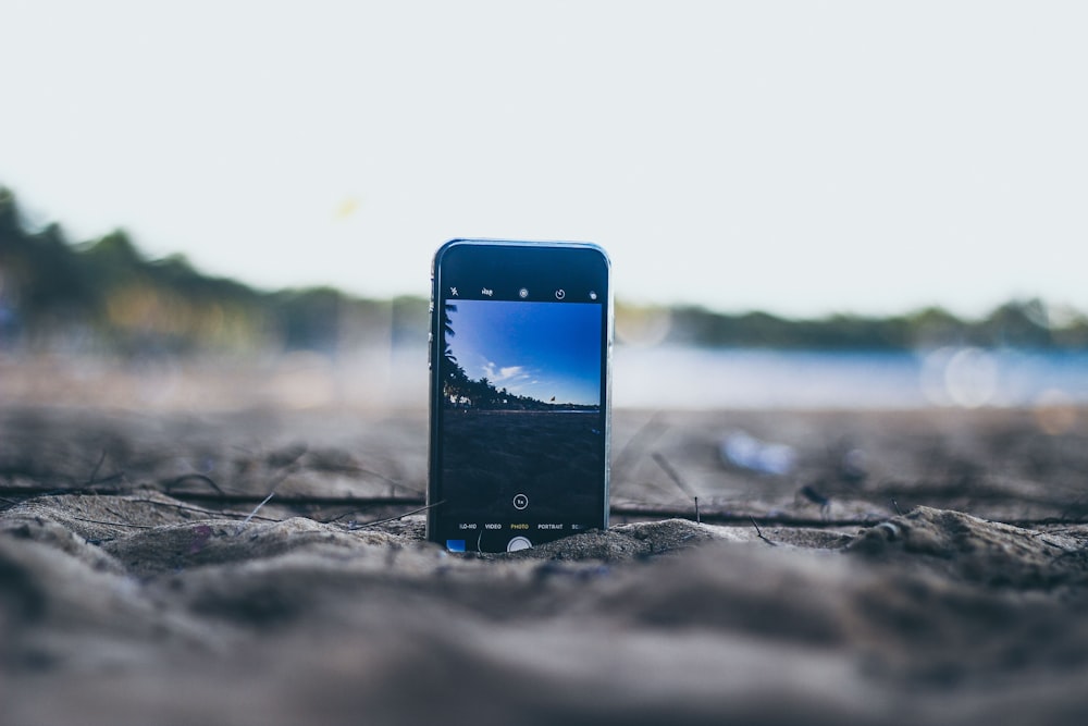 bokeh photography of smartphone standing on soil