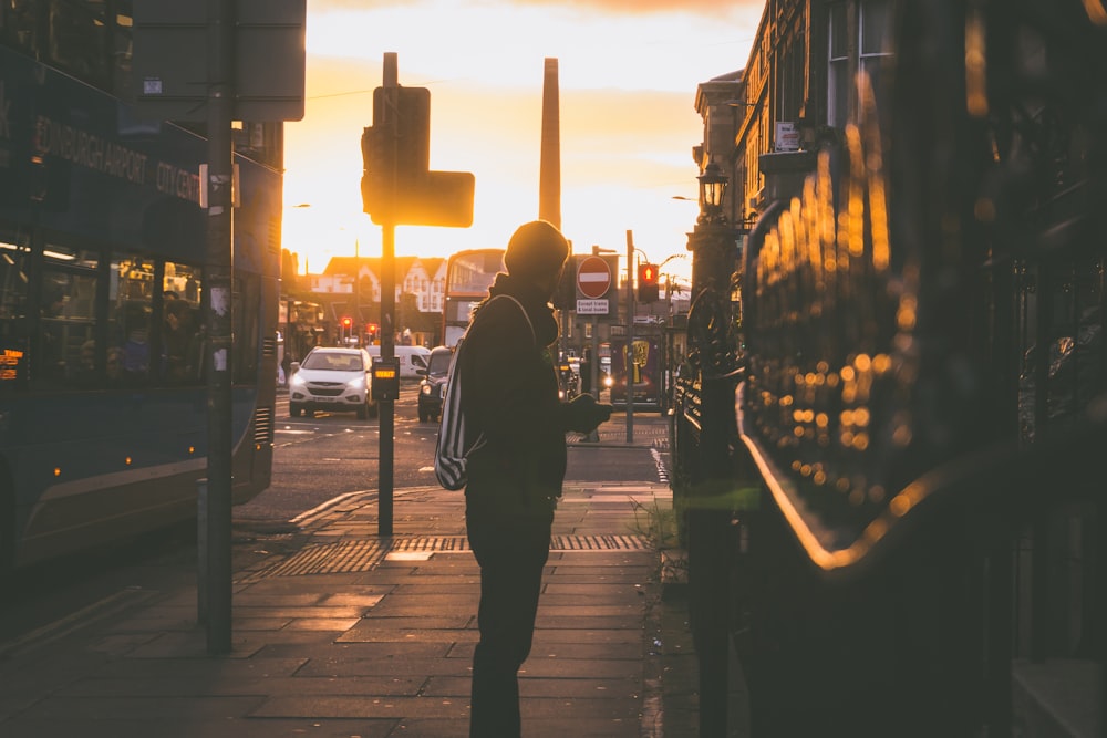 silhouette photography of man standing in front of building