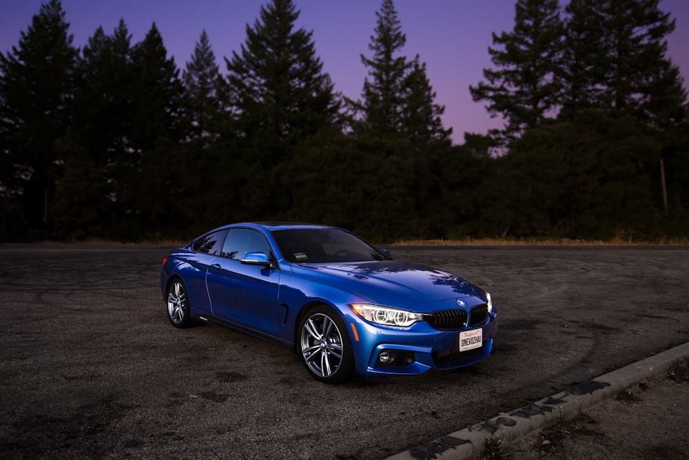 blue BMW coupe on brown asphalt road