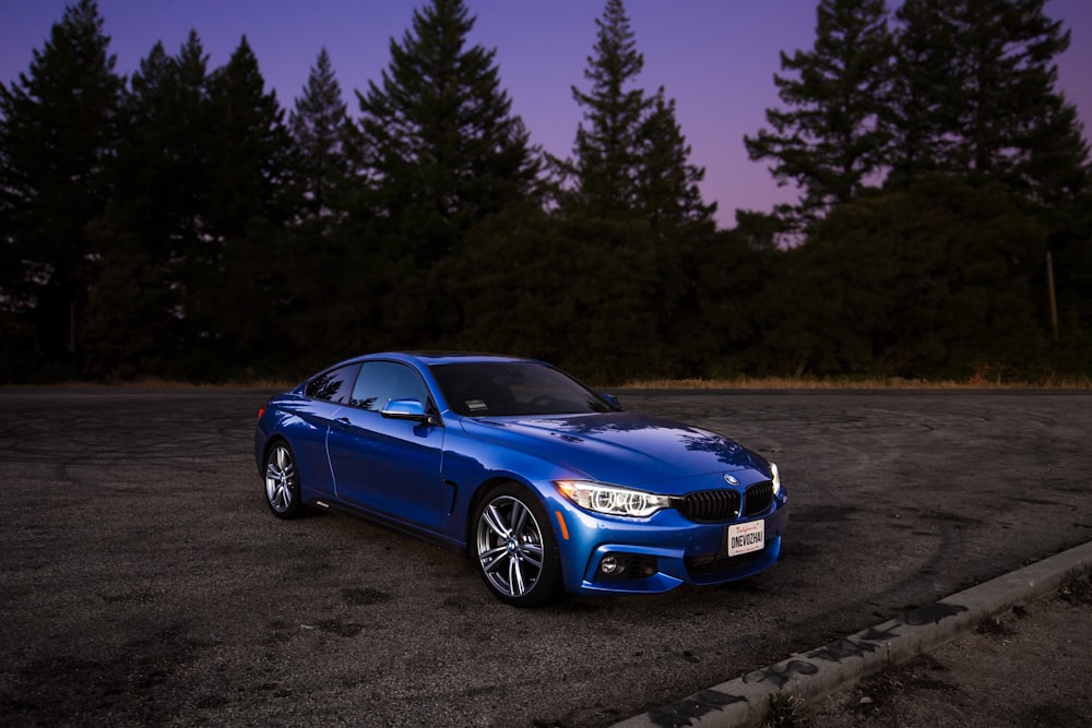 BMW coupé azul sobre carretera de asfalto marrón