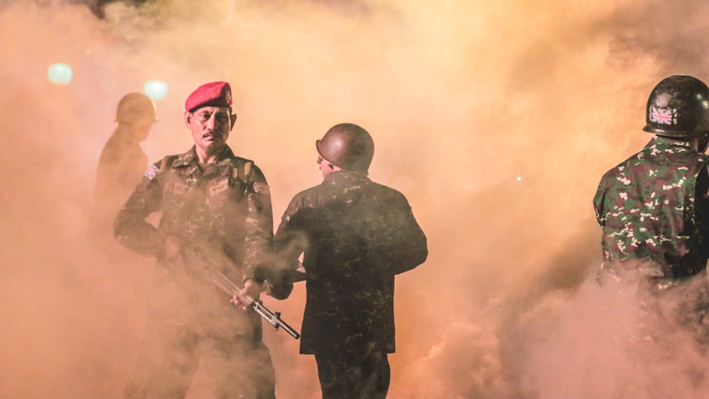 Groupe de soldat tenant un fusil entouré de fumée