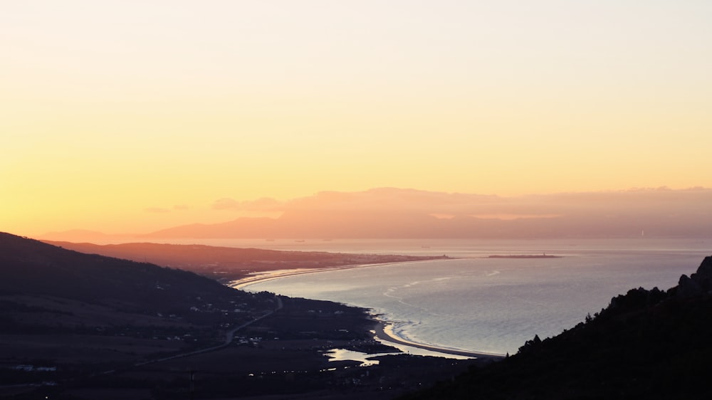 body of water beside mountains