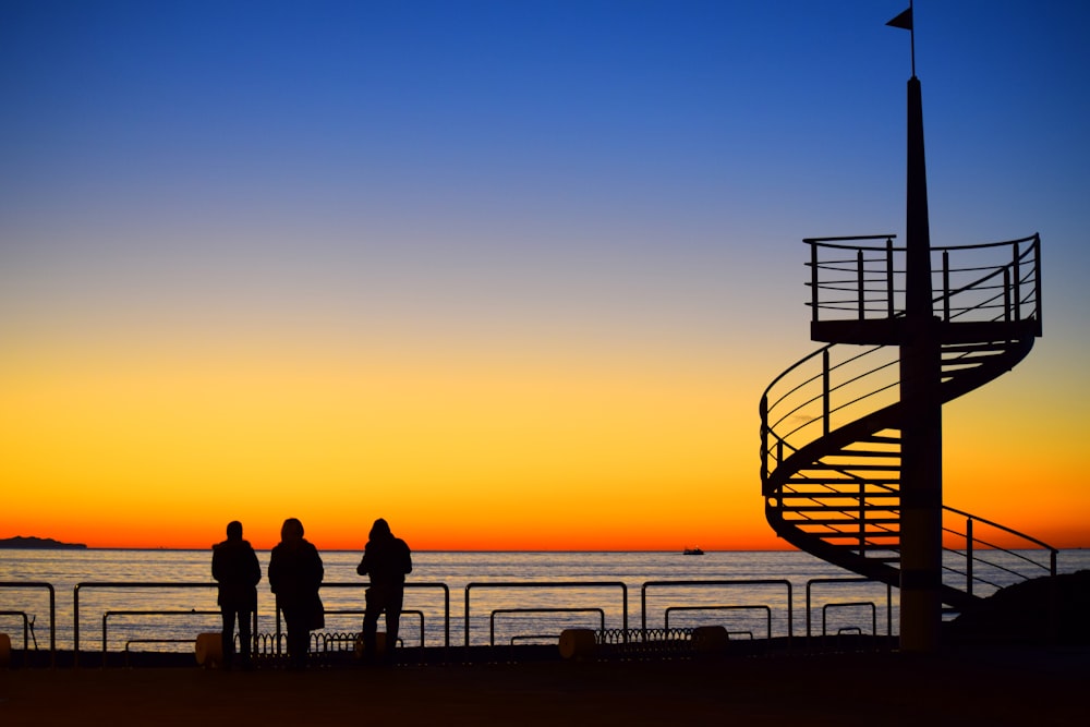 three person watching sunset