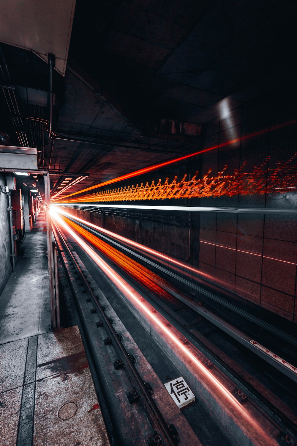 Cruzamento de luz vermelha e cinza na estrada sob o túnel em fotografia timelapse