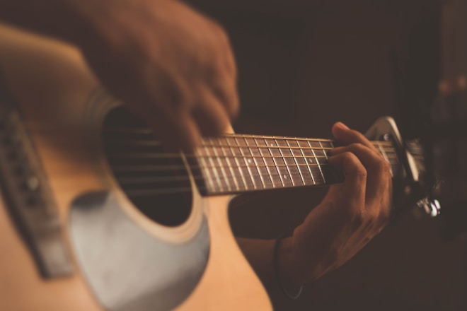 Musician playing acoustic guitar on stage