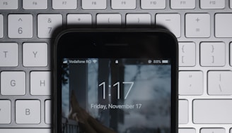 black iPhone on gray computer keyboard