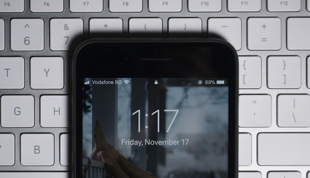 iPhone noir sur clavier d’ordinateur gris