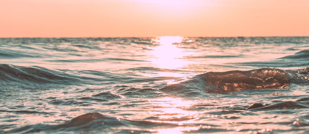 foto de ondas do mar com reflexo do sol