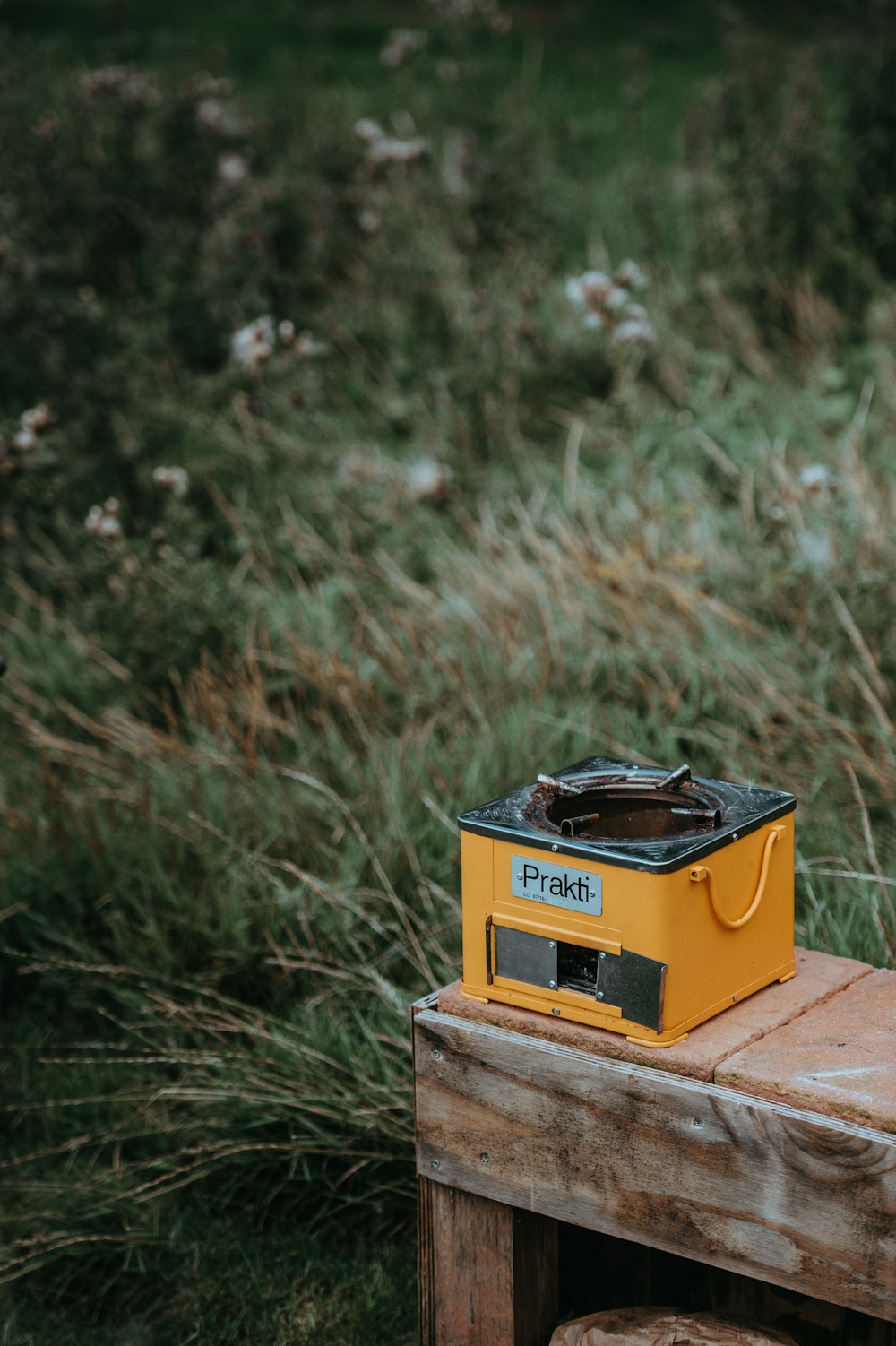 square yellow and black charcoal burner on wooden table