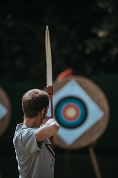 Close-up of an archer releasing an arrow at a foam 3D deer target