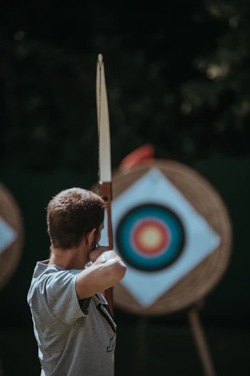 A close-up of an archer aiming precisely at a target, symbolizing focus and discipline.