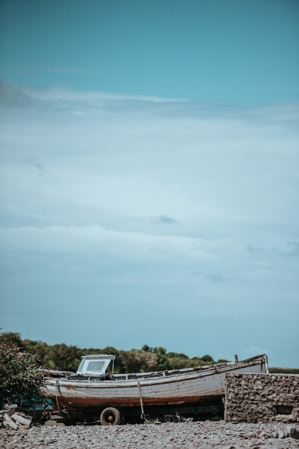 white and brown speedboat on boat trailer