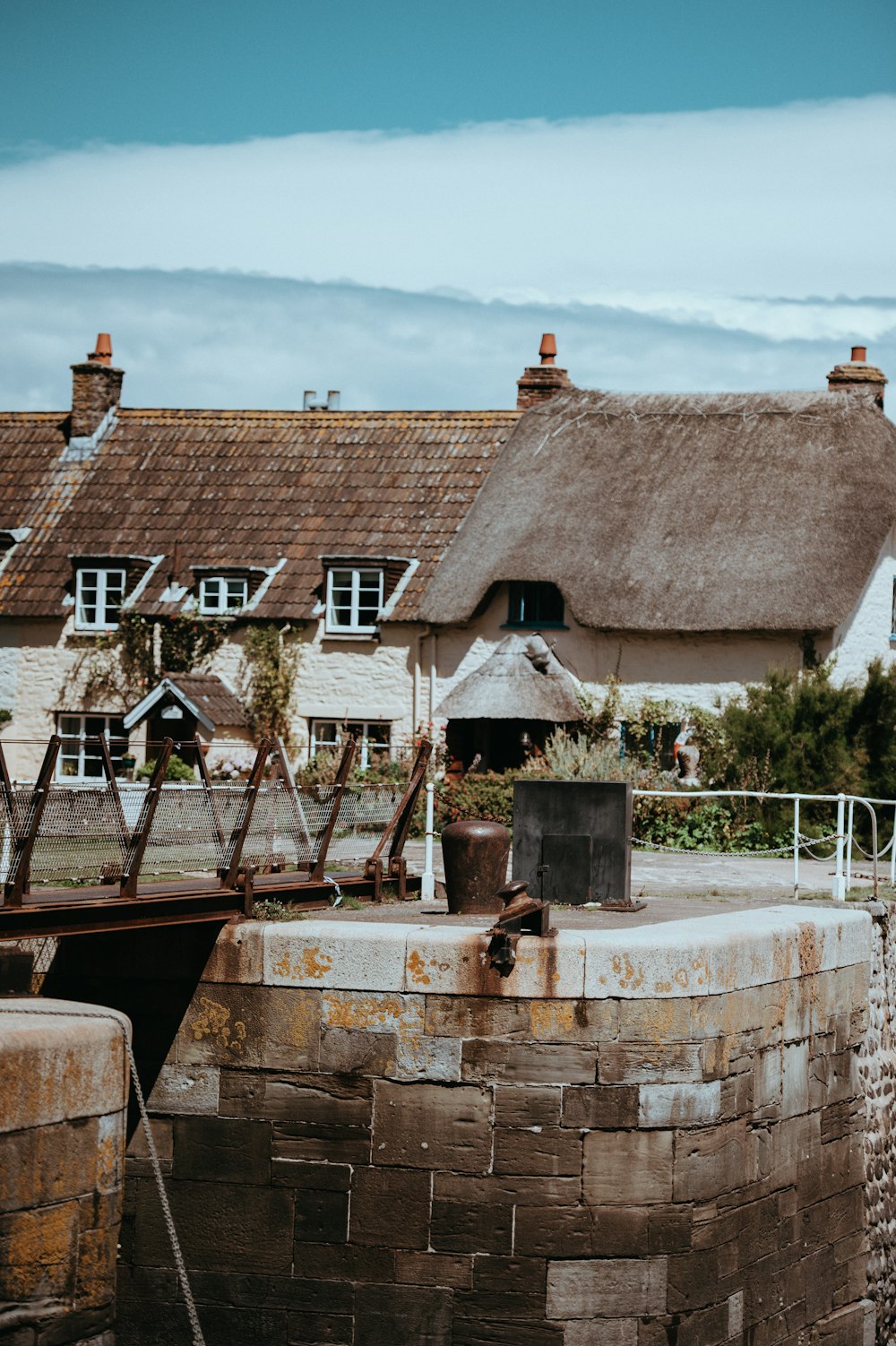 a house with a thatched roof next to a body of water
