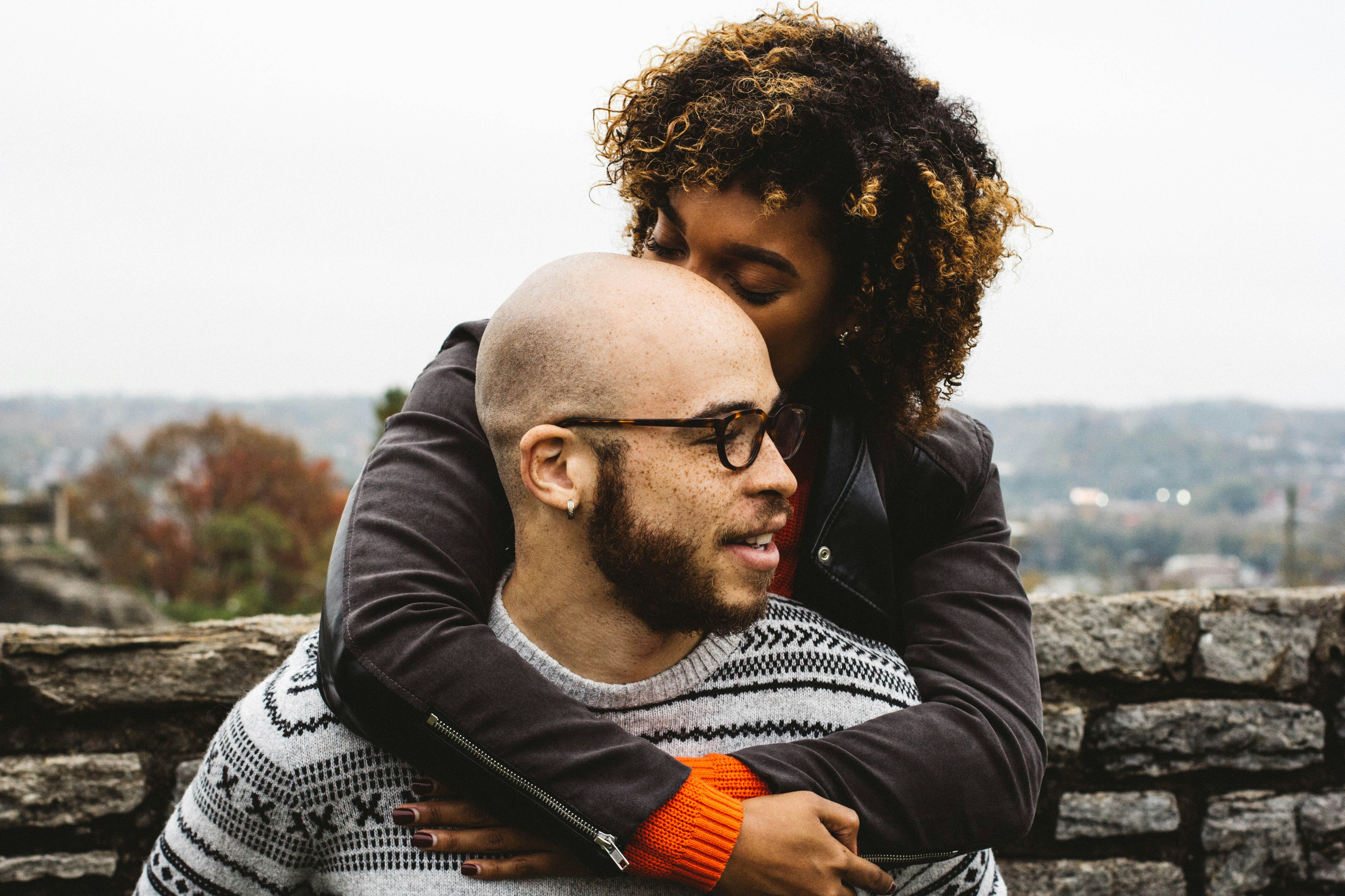 woman kissing man's head