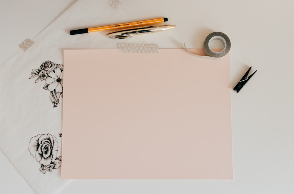 Tableau blanc à côté d’un crayon et d’un ruban adhésif