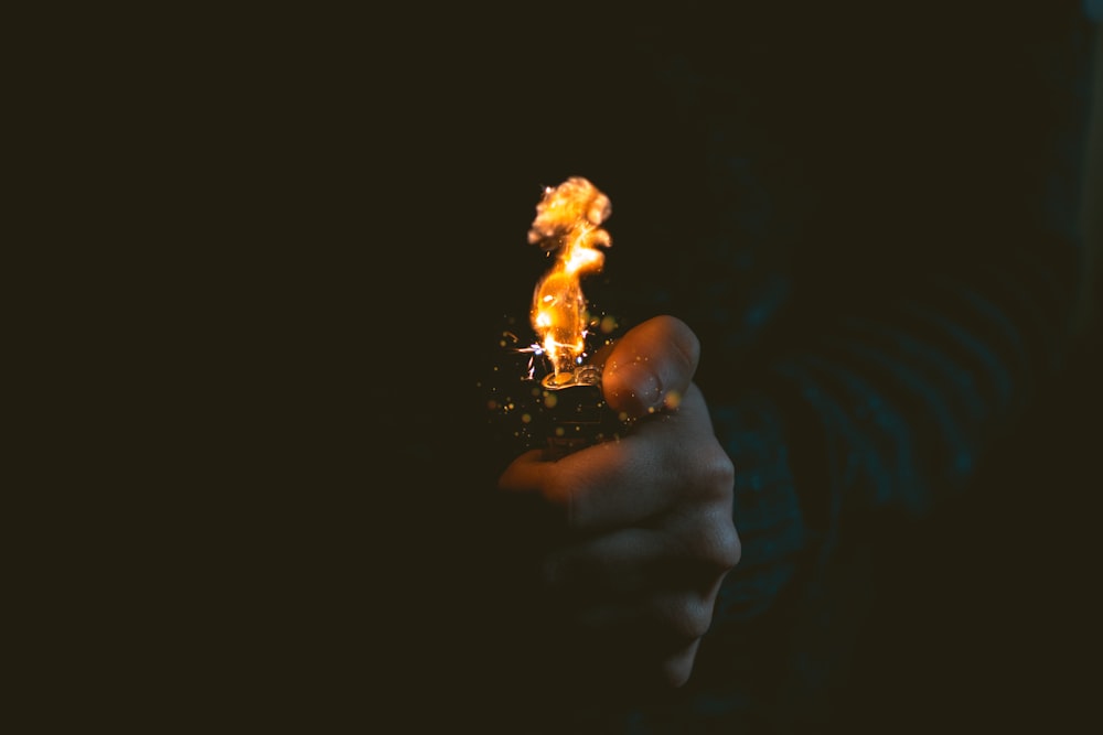 person holding lighted lighter