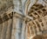 Detailed architectural elements of a historic stone structure featuring ornate carvings and intricate designs. The stonework includes decorative patterns on the arches and pillars, showcasing the craftsmanship of classical architecture.