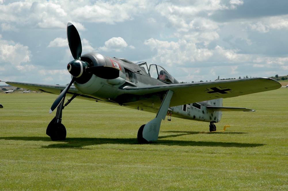 L’avion gris allemand BF 109 est garé sur le terrain d’herbe verte