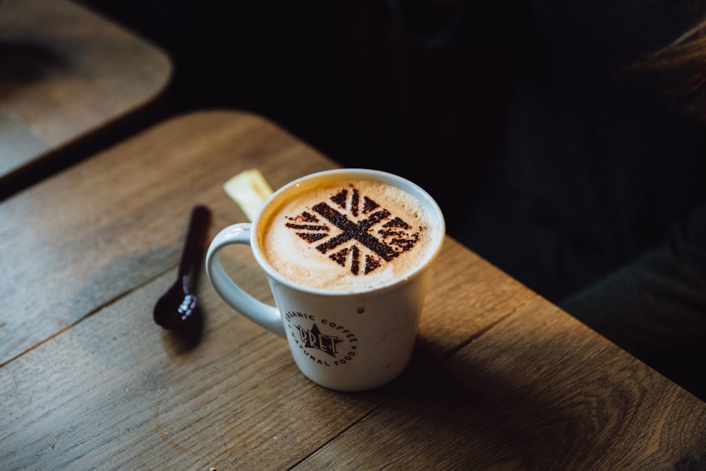 white ceramic coffee mug on brown wooden table