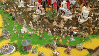 A vibrant nativity scene with colorful ceramic characters and miniature animals.