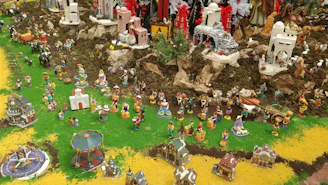 A vibrant nativity scene with colorful ceramic characters and miniature animals.