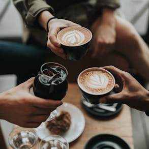 three person holding mug and glass with beverage inside