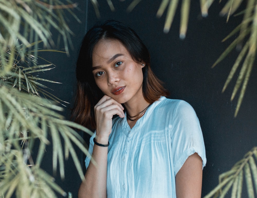 woman wearing teal shirt against grey background