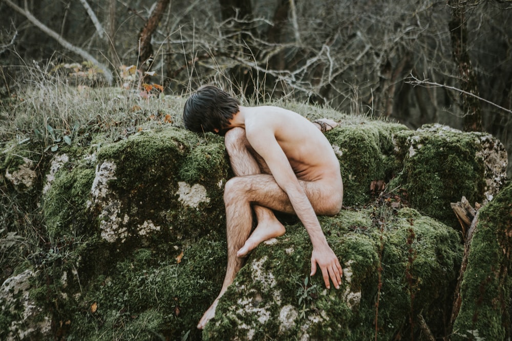 naked person sitting on green grass