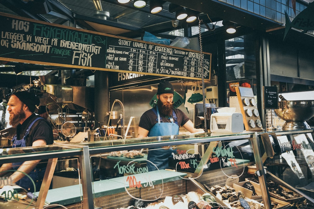 man standing behind glass display counter