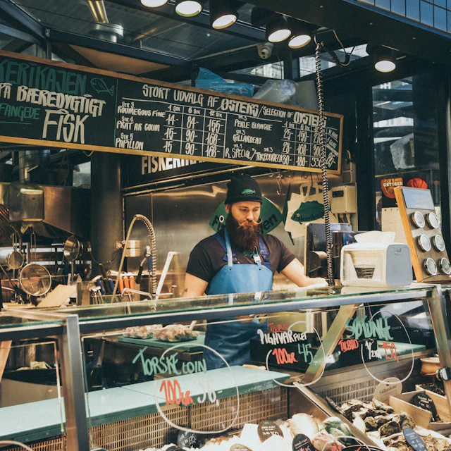 Man standing behind a glass deli display counter