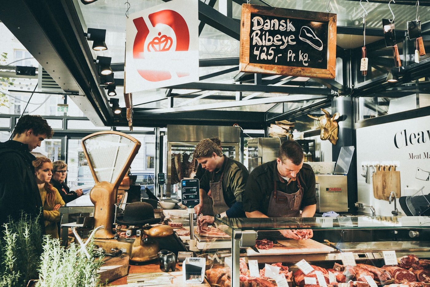 A group of customers at a butcher shop counter