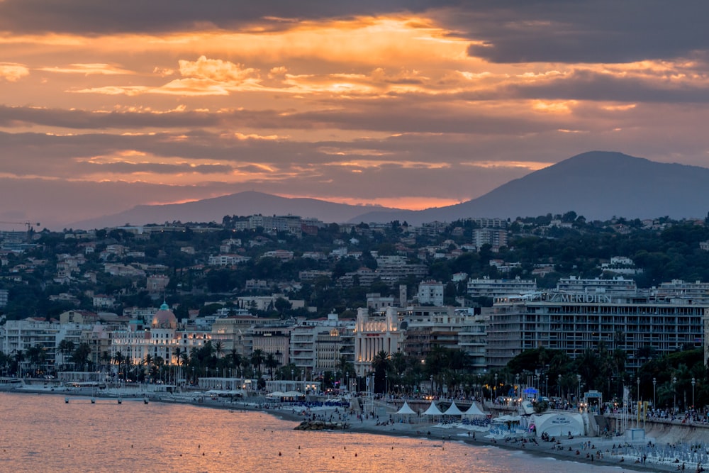 foto aerea della città accanto allo specchio d'acqua durante il tramonto