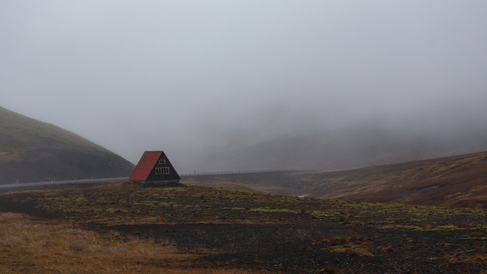 red wooden house distance with road and mountains during fog