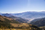 A panoramic view of the Andes mountains with a traveler enjoying the vast landscape.
