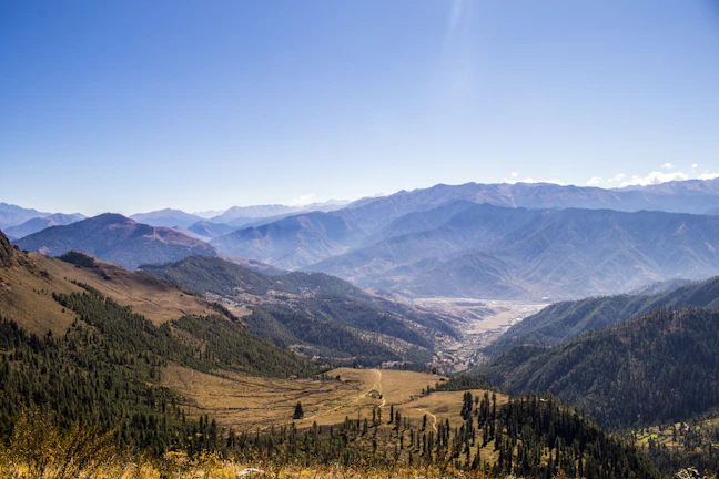 A panoramic view of the Andes mountains with a traveler enjoying the vast landscape.