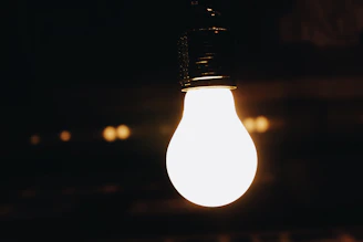 A bright LED bulb glowing warmly in a cozy living room setting.