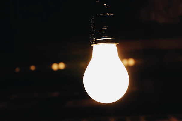 A bright LED bulb glowing warmly in a cozy living room setting.