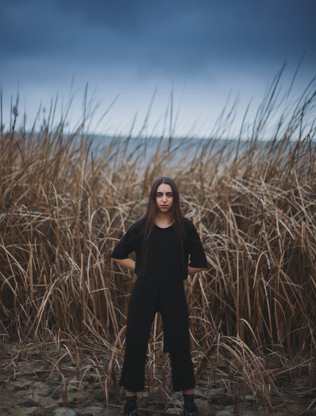 woman standing near brown grass field