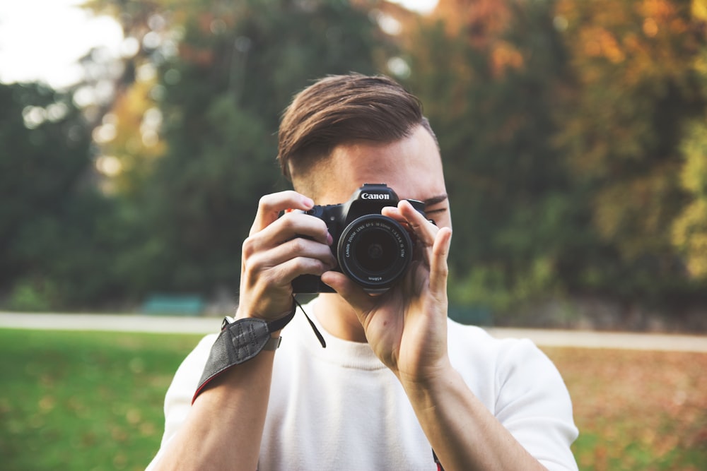 person holding DSLR camera