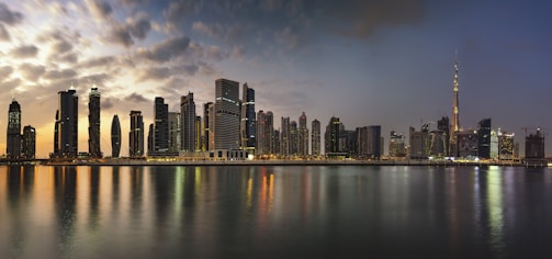 A panoramic view of a modern city skyline at dusk.