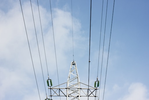 white steel electric post under white clouds